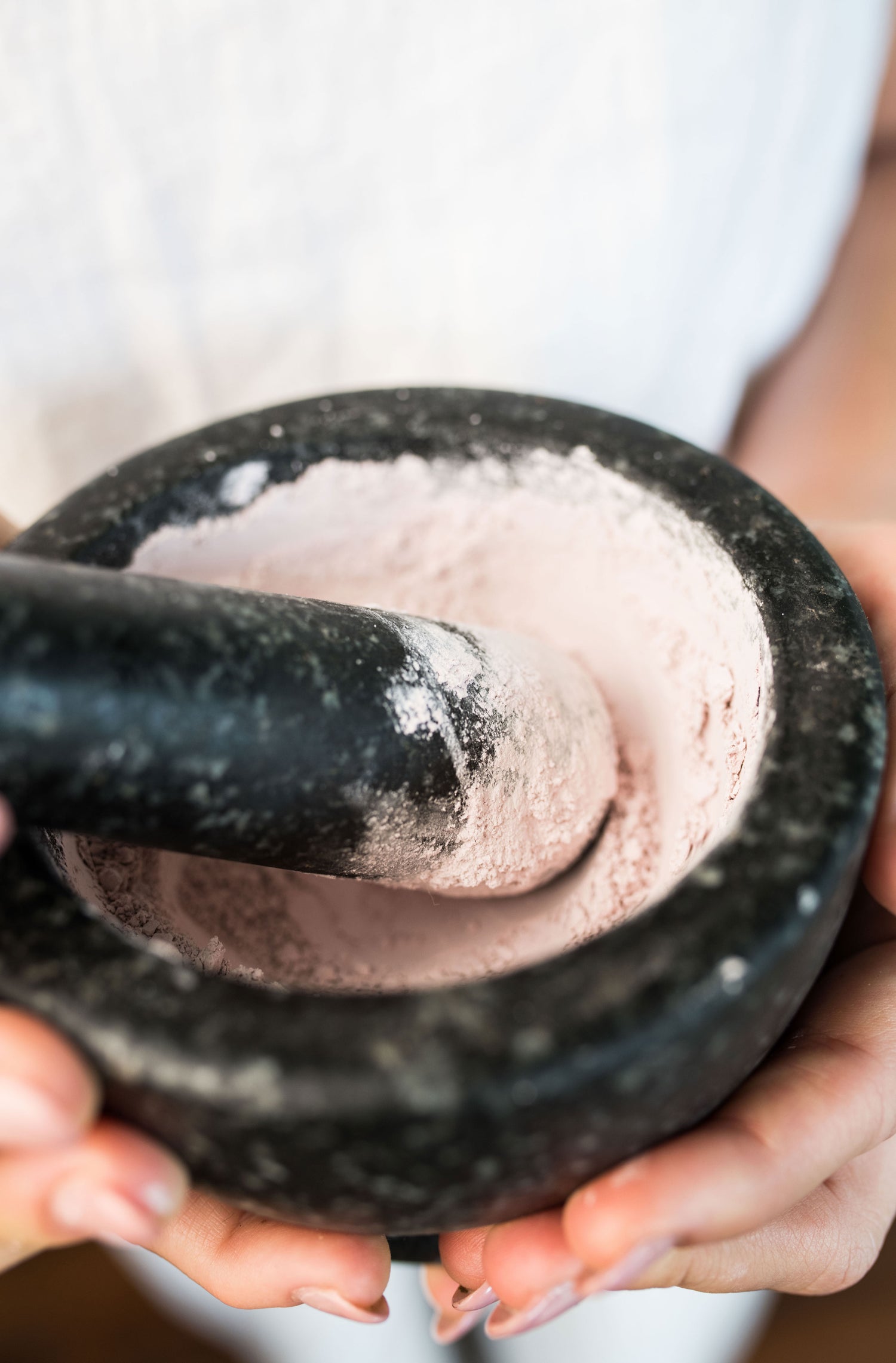 Skin care ingredients being ground in a pestle mortar
