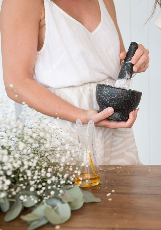 Female preparing product ingredients with a Pestle Mortar