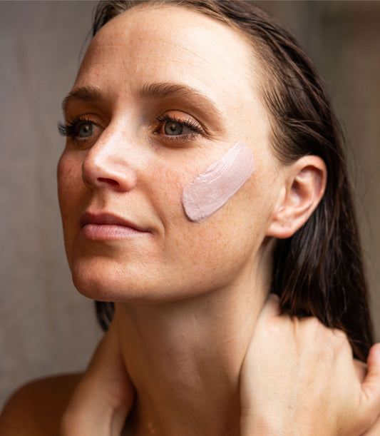 Female face with skin care mask on cheek